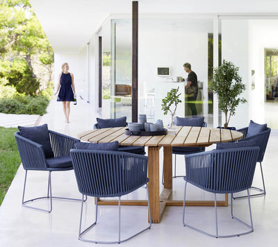 Dining set shown on terrace with two people in the background