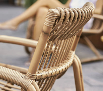 Detail of back of a beige woven outdoor armchair