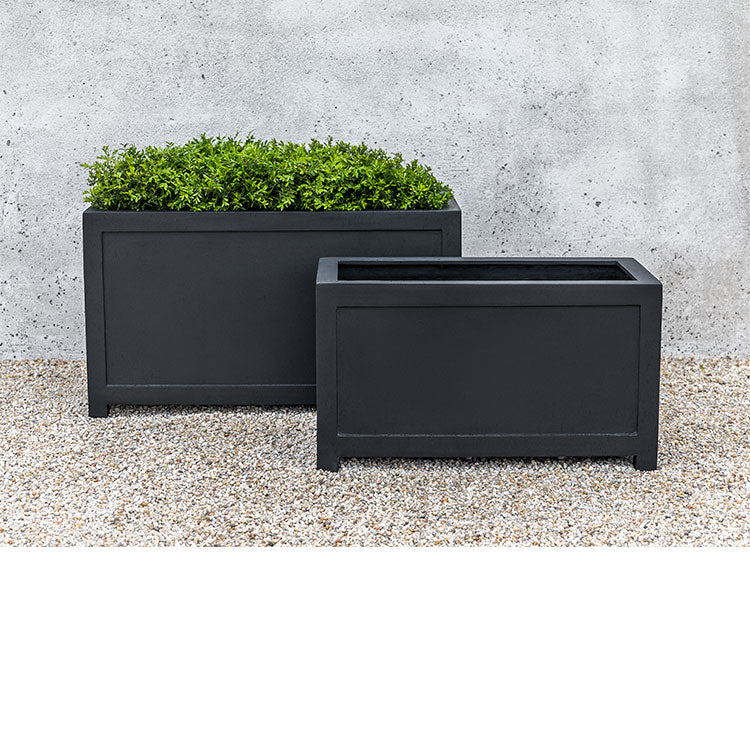Two rectangular containers in front of grey wall
