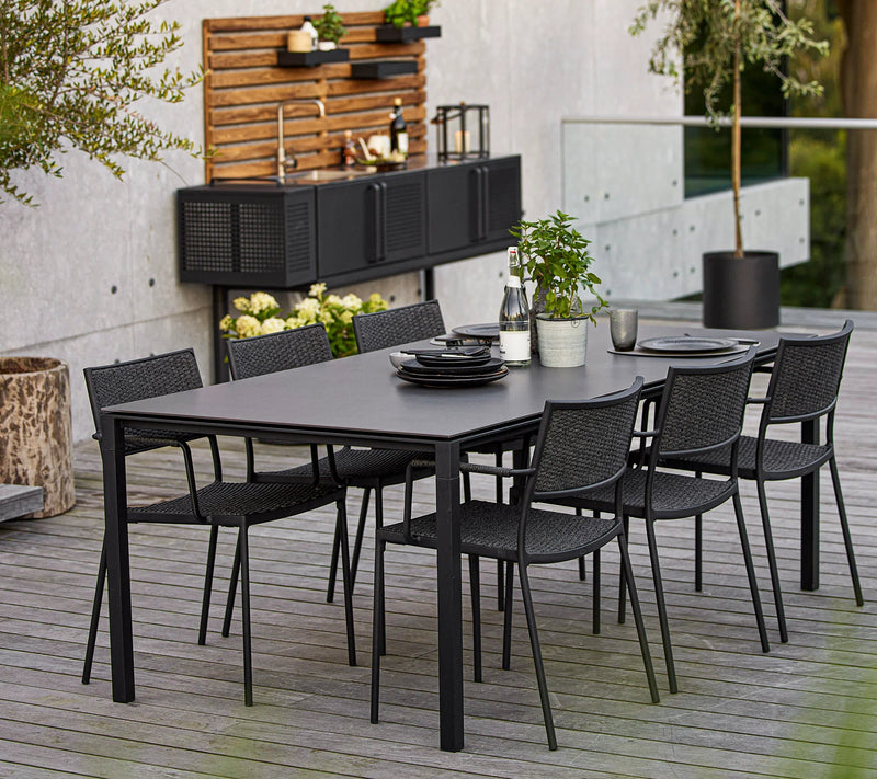 Black dining set in front of outdoor kitchen