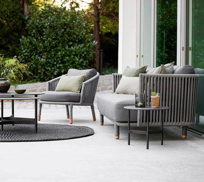 Grey outdoor furniture set on light patio with round rug