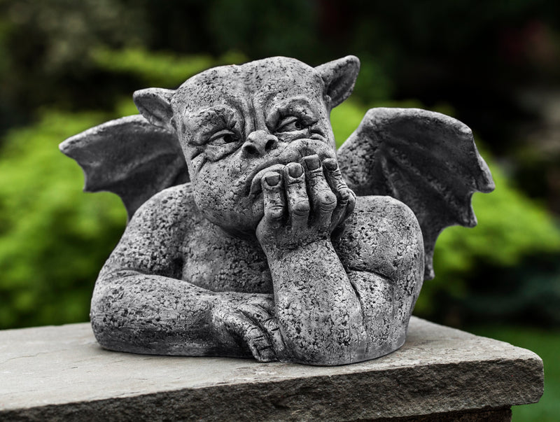 Little gargoyle head and torso with hand holding face and wings spread out