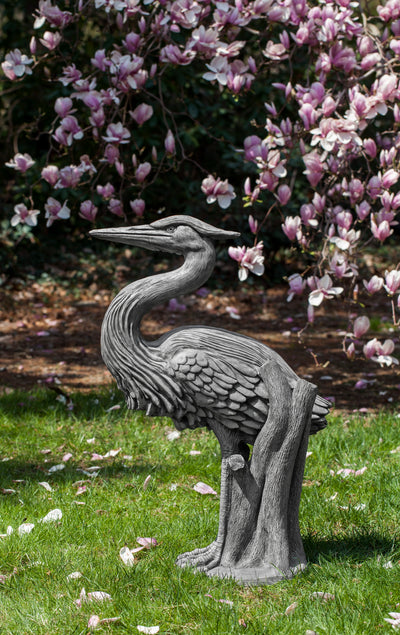 Gray heron standing in front of blooming tree