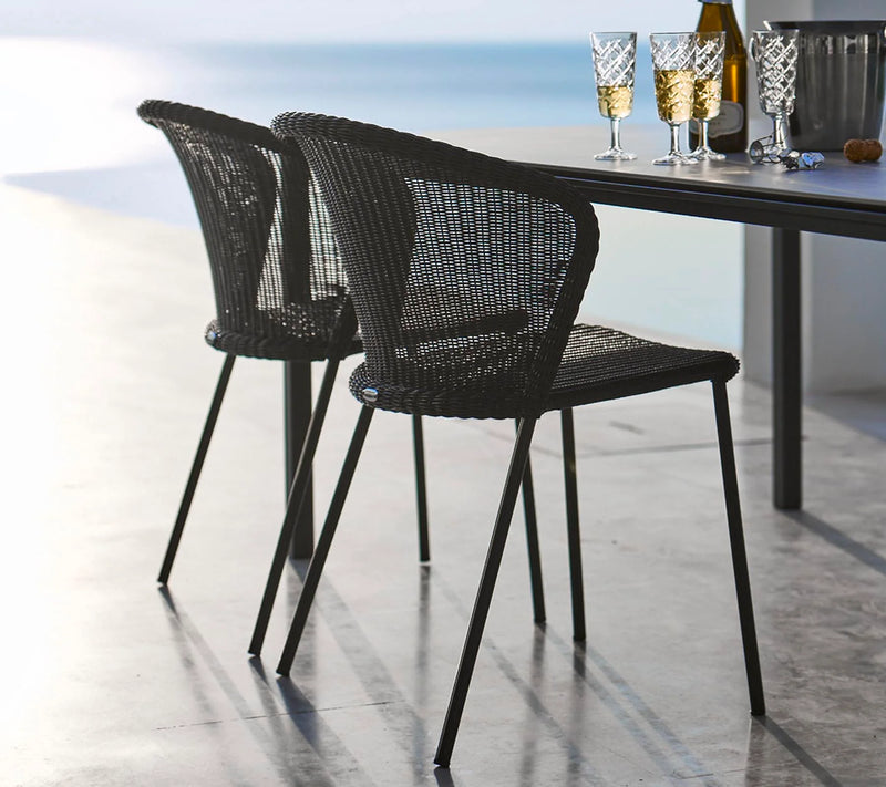 Two black armchairs close to table with wine glasses