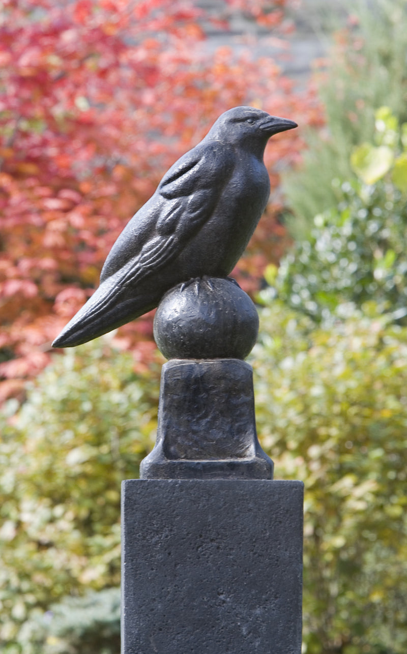 Black raven sitting on a finial