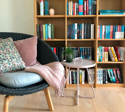 Armchair and coffee table in front of library shelves