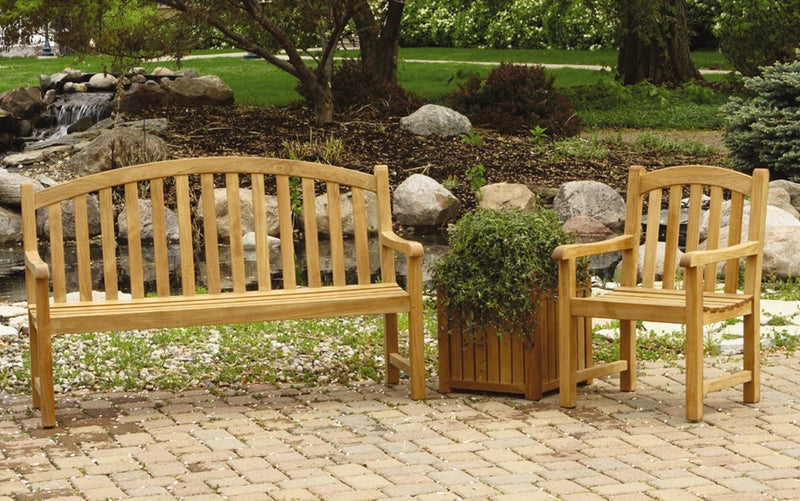 Teak bench and armchair shown on paver patio with rock garden in the background