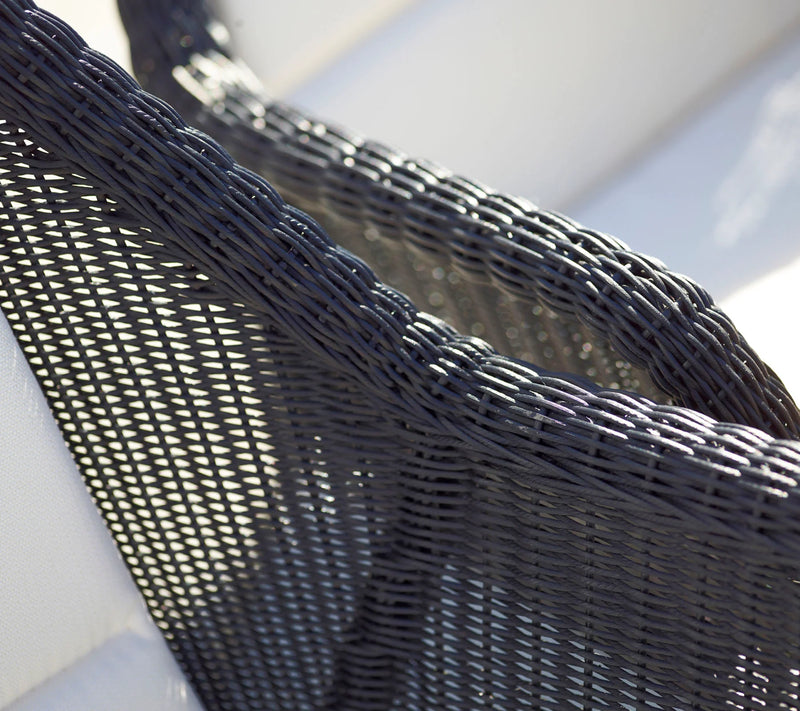 Close up of a light gray woven outdoor armchair