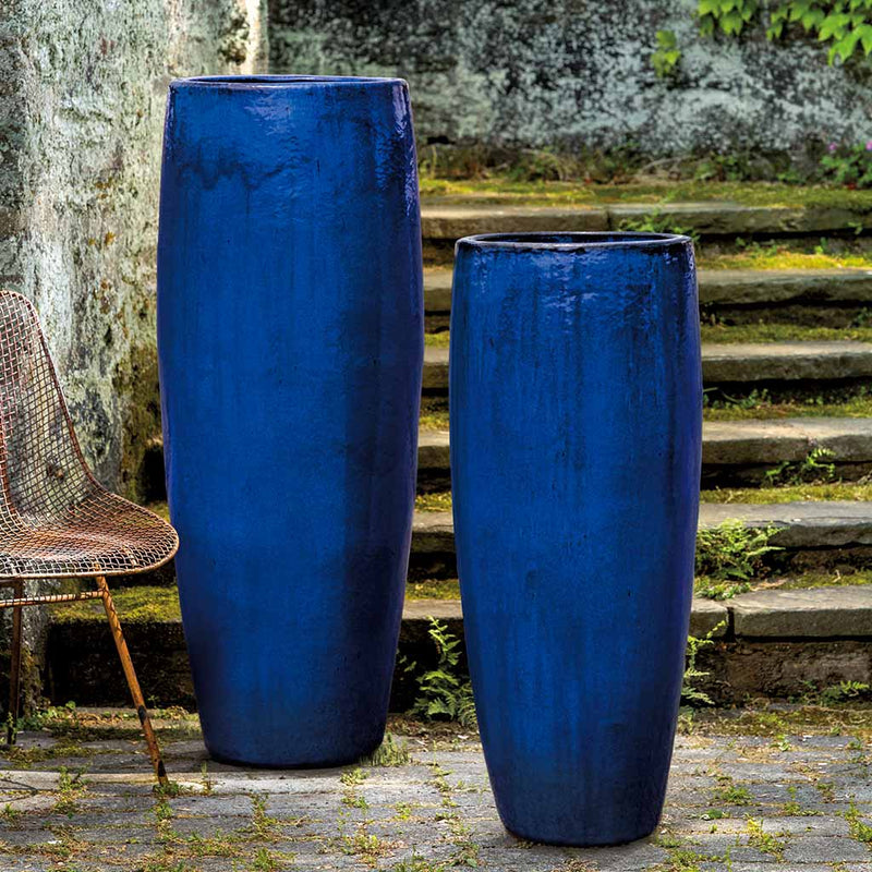 Tall blue containers shown in front of  mossy steps