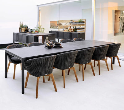 Dining set with rectangular table and ten matching chairs in front of kitchen