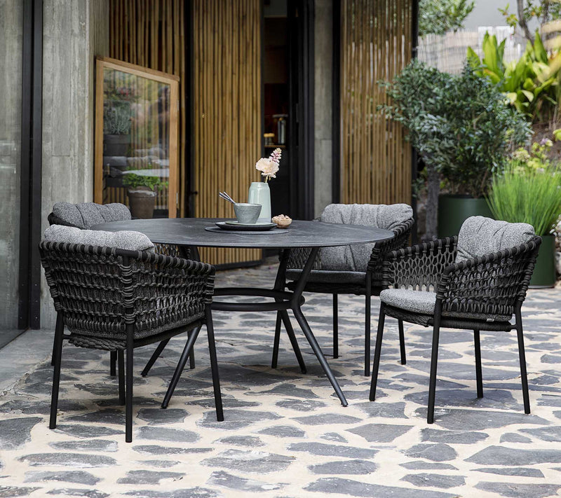 Dining set with black table and chairs shown on slate terrace