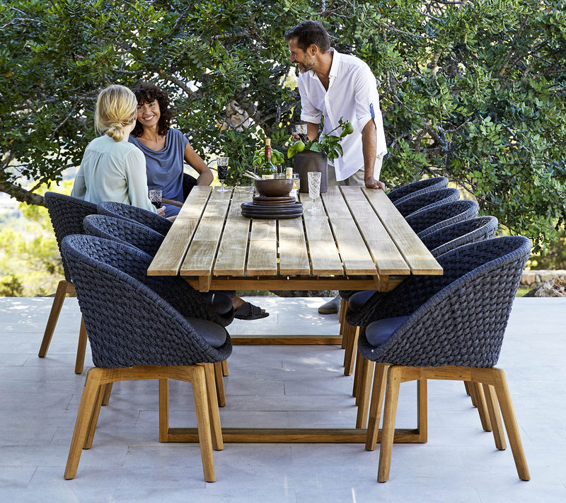 Dining set with eight chairs and three people talking at one end