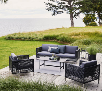 Deep seating set shown on wooden deck by a lawn and ocean views