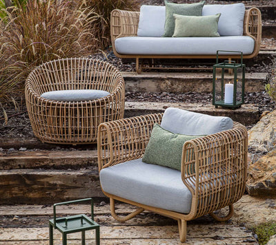 Outdoor furniture displayed on different levels next to grasses and lanterns