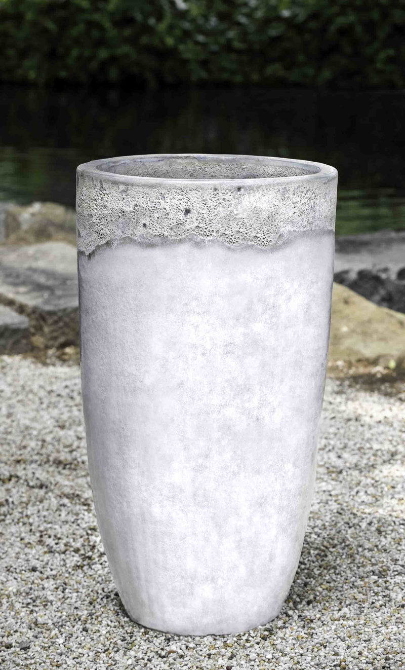 Tall white container shown on gravel floor