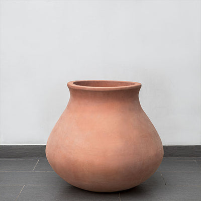 Terra cotta urn shown in front of wall