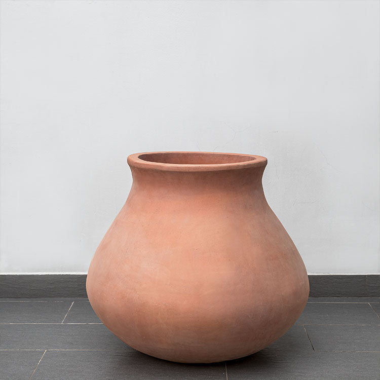 Terra cotta urn shown in front of wall