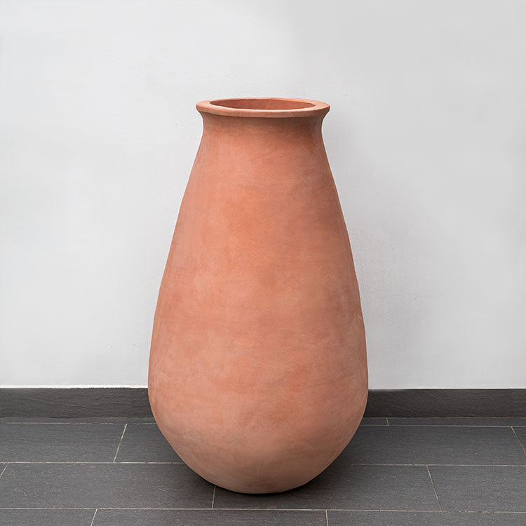 Tall terra cotta container shown in front of wall