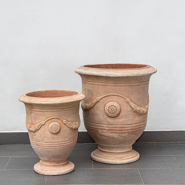 Set of 2 terra cotta urns in front of wall