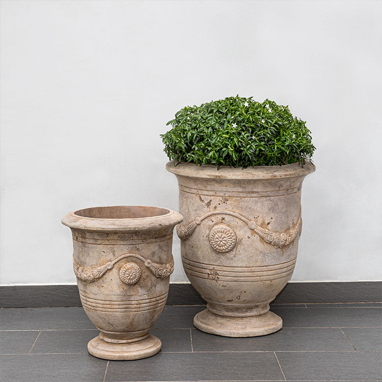 Set of 2 terra cotta urn in front of wall