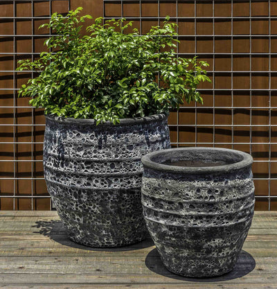 Set of 2 dark blue rustic containers in front of metal fence