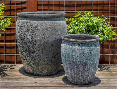 Set of 2 rustic containers in front of metal fence