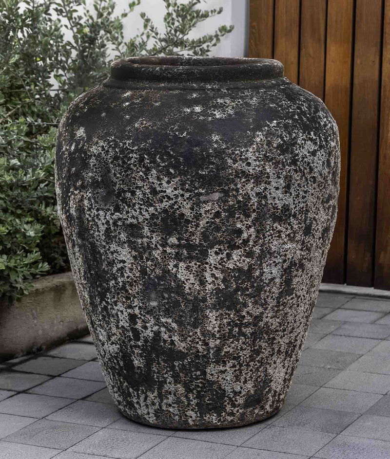 Large rustic urn in front of wooden door