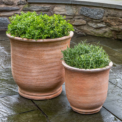Set of 2 ribbed terra cotta containers on stone patio