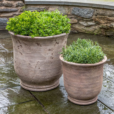 Set of 2 cribbed terra cotta containers on stone patio