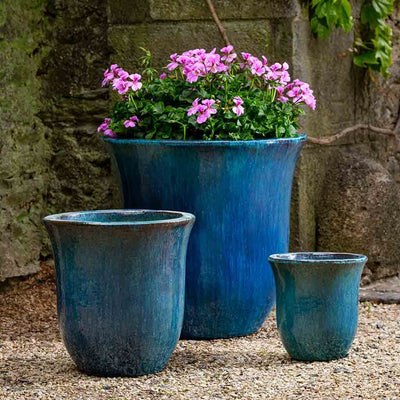 Grouping of 3 blue containers shown on gravel ground