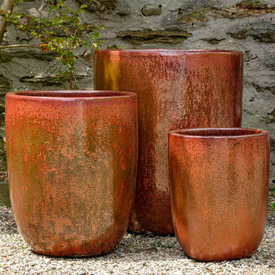 Grouping of 3 red containers shown in front of stone wall