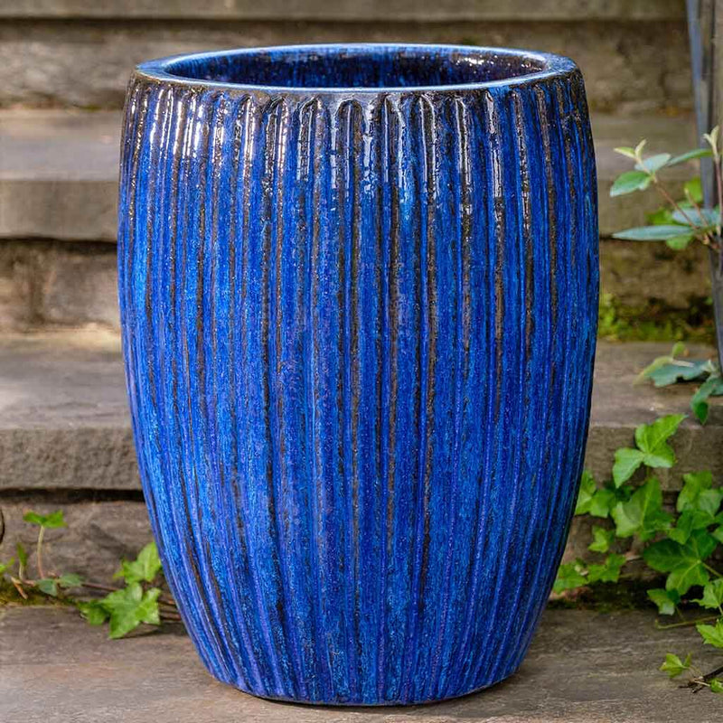 Tall blue ribbed container in front of steps
