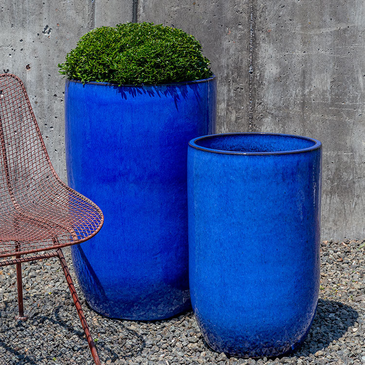 Set of 2 blue containers shown in front of concrete wall