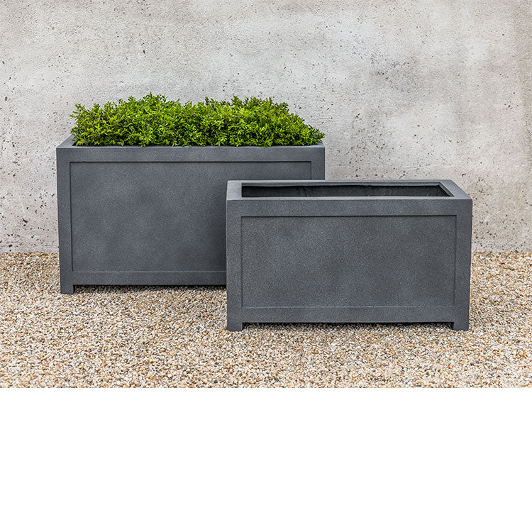 Two rectangular containers in front of grey wall