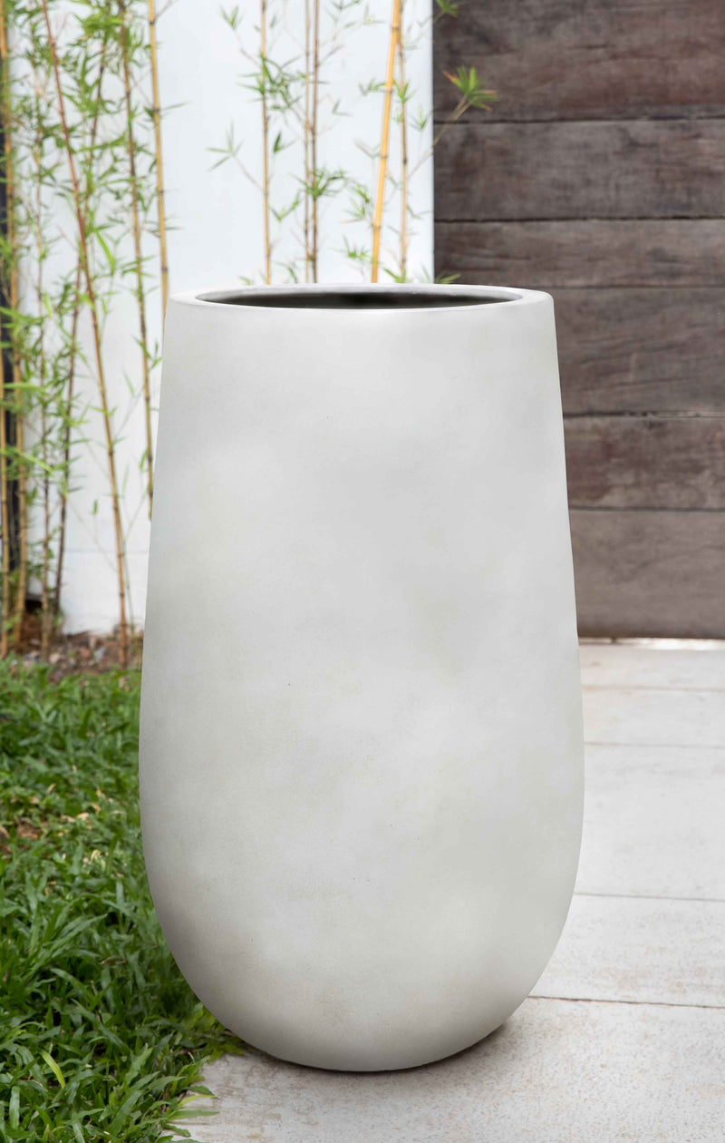 Tall white container in front of bamboos