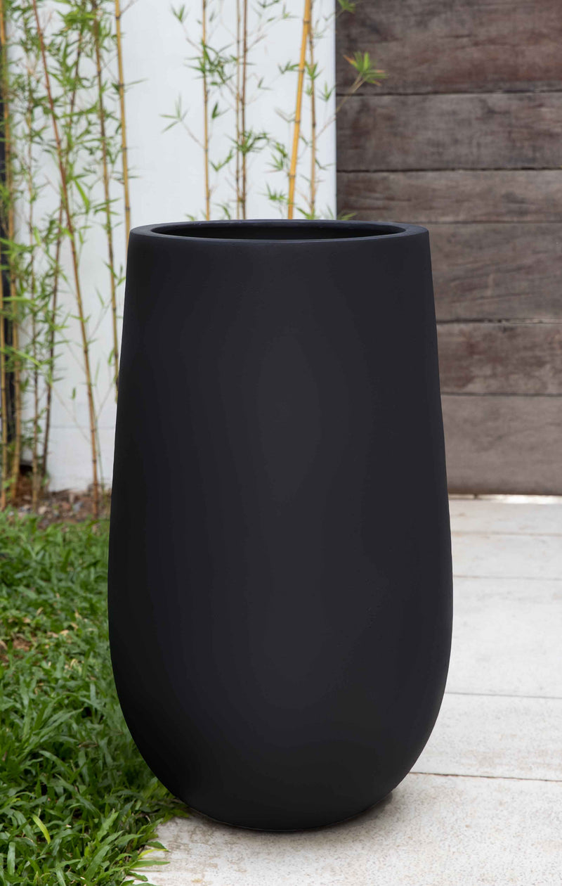 Tall black container in front of bamboos