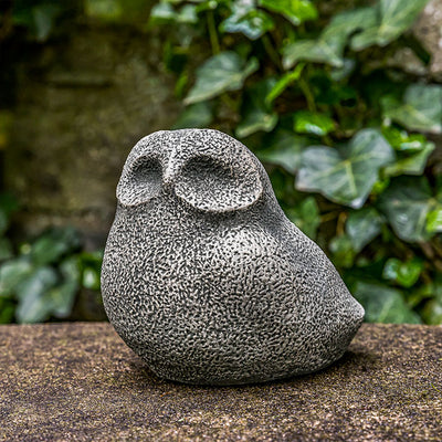 Stylized owl with pitted texture sitting on wall