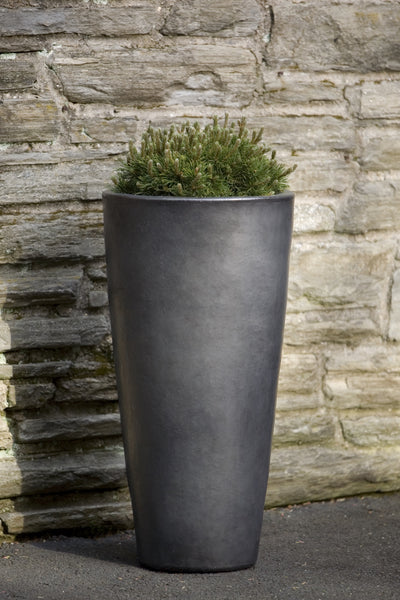 Tall and narrow grey container in front of stone wall