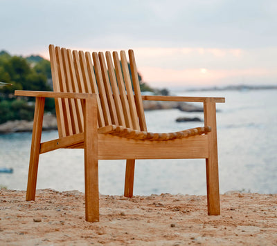Contemporary teak armchair on beach