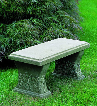 Small bench with snowdrop design details on the feet pictured on grass
