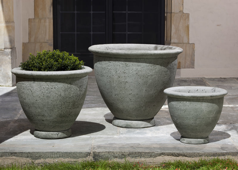 Trio of concrete pots pictured in front of black window