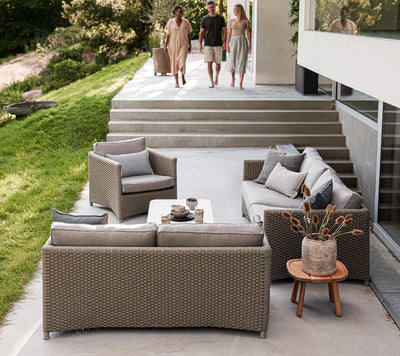 People walking down steps to sitting area with two couches and one armchair