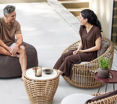 Couple sitting on outdoor furniture next to a matching coffee table
