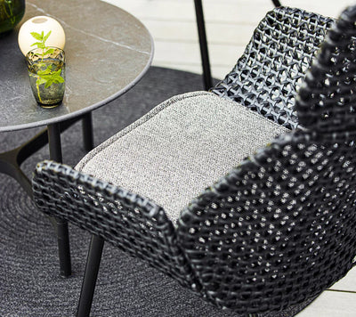 Grey armchair on grey outdoor rug