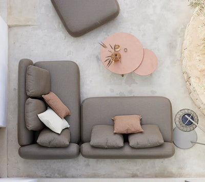 Corner sitting set behind two rose colored coffee tables