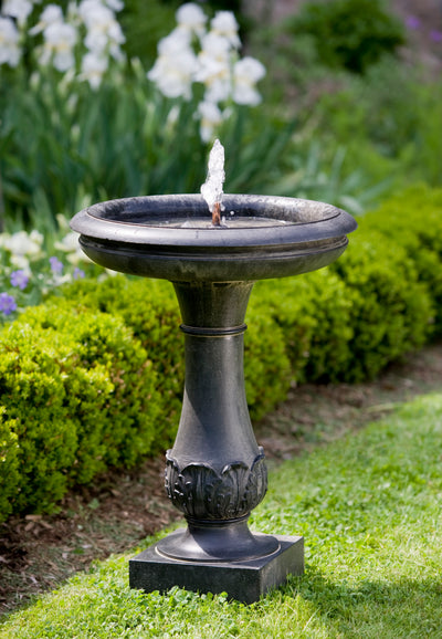 Birdbath fountain with copper spout in the middle and greenery details on pedestal