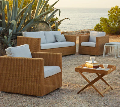 Deep sitting set shown on gravel patio and ocean in the background