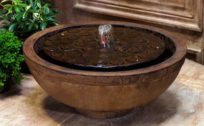 Brown table top fountain with covered bowl and copper spout pictured on table
