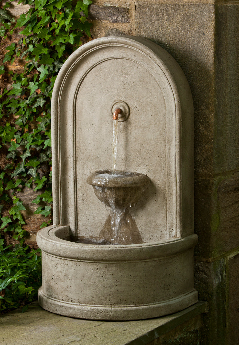Wall fountain with a copper spout on curved back and two bowls pictured against wall
