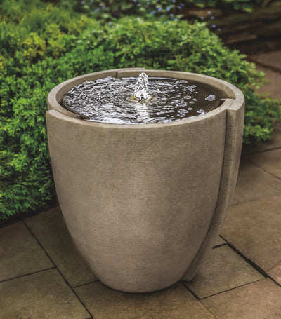 Container shaped fountain with covered top and copper spout  on pavers